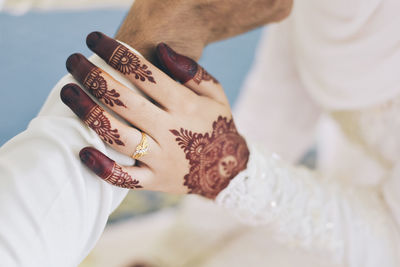 Midsection of bride holding bridegroom hand during wedding