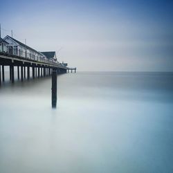 Scenic view of pier on sea against sky during misty morning