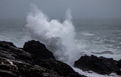 Waves breaking on rocks against sea