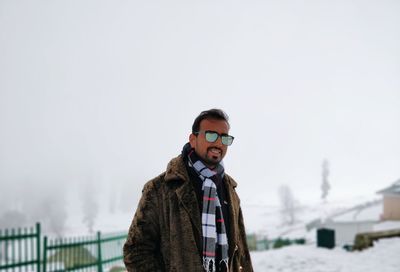 Portrait of young man standing on snow