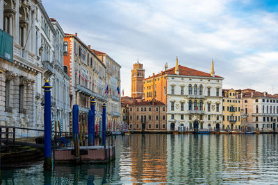 Canal amidst buildings in city against sky