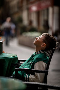 Side view of woman sitting on chair