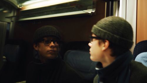 Reflection of boy on glass window in train