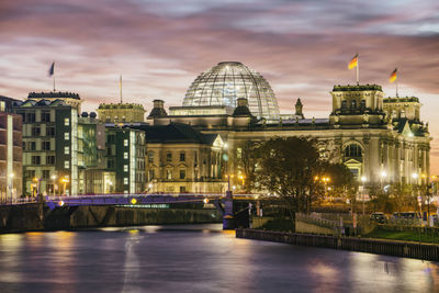 View of illuminated bridge over river at dusk