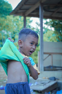 Angry cute boy removing t-shirt