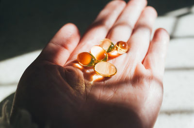 Cropped hand holding capsules in home