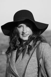 Portrait of smiling woman in hat at beach