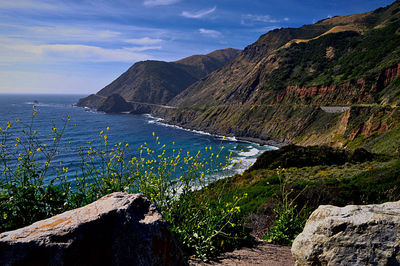 Scenic view of sea and mountains against sky