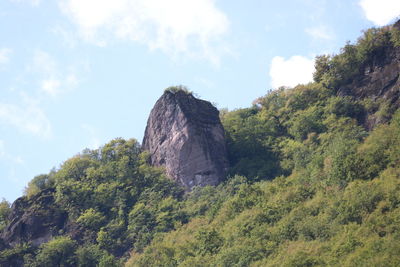 Low angle view of rocks on mountain against sky