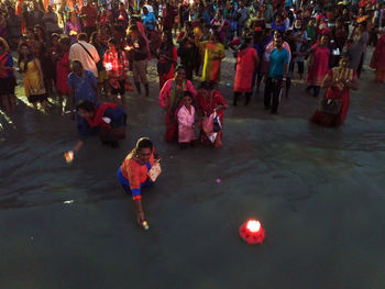 High angle view of people enjoying in water at night