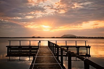 Pier over sea against sky during sunset