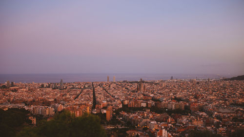 High angle view of townscape by sea against clear sky