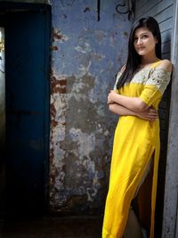 Portrait of woman standing against shutter at night