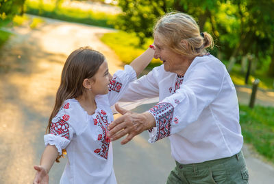 Girl embracing grandmother outdoors