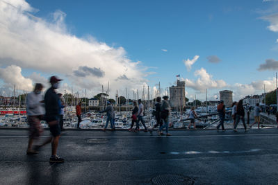 People walking on street against sky