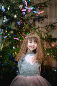 Portrait of happy girl with christmas tree