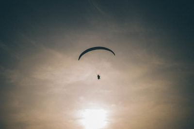 Low angle view of parachuting against the sky