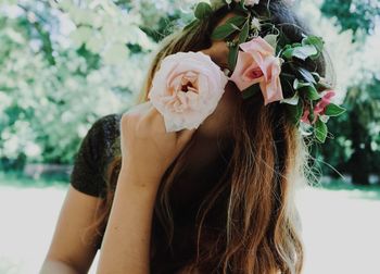 Close-up portrait of young woman wearing flowers outdoors