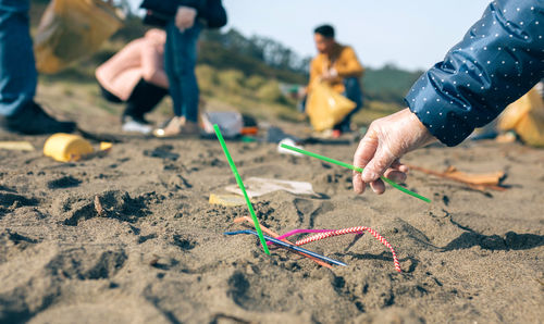 Low section of people holding hands on land