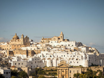 Buildings in city against clear sky