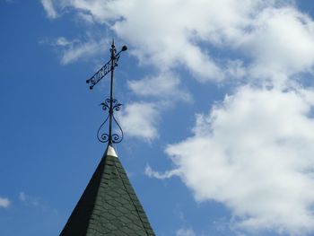 Low angle view of weather vane against blue sky