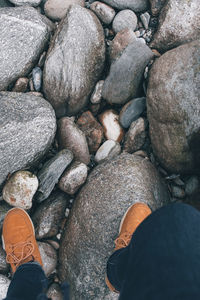 Low section of person standing on pebbles