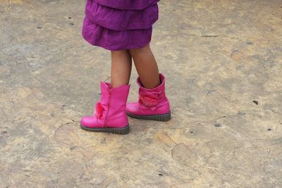 Low section of woman standing on pink road