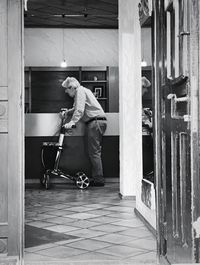 Side view of man standing against building