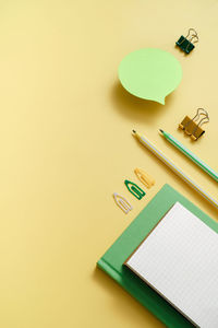 High angle view of pen and pencil on yellow background