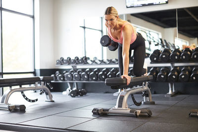 A woman exercising with weights in a gym.