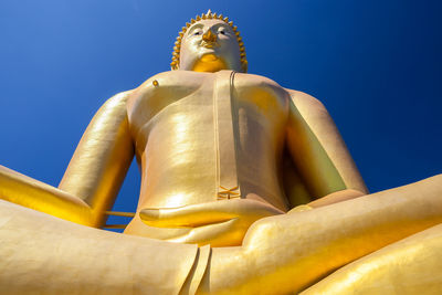 Low angle view of statue against blue sky