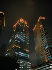 Low angle view of illuminated buildings against sky at night