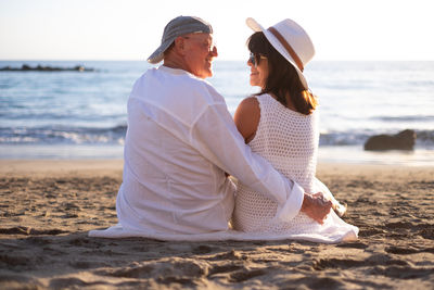 Side view of woman sitting at beach