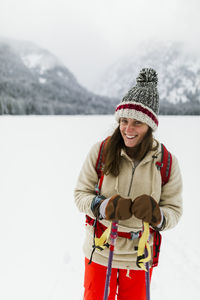 Portrait of smiling woman hiking on snow covered field