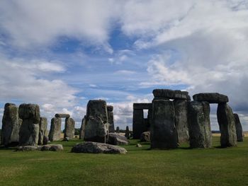 Old ruins in field against cloudy sky