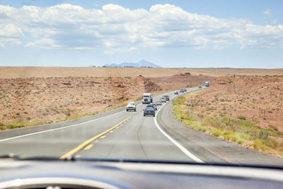 Vehicles on country road seen through car windshield