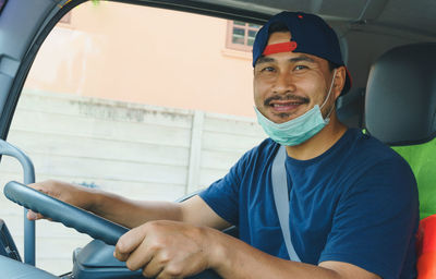 Portrait of young man sitting in car