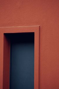 Close-up of gray door on red wall