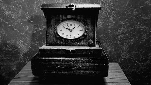 Close-up of clock on table against wall