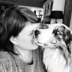 Close-up of dog licking woman face 