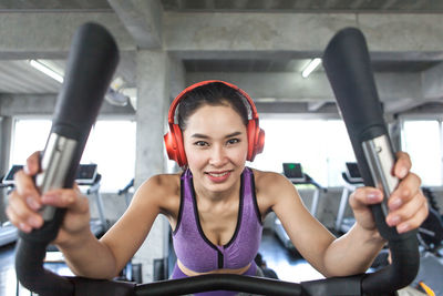 Portrait of smiling woman exercising on treadmill