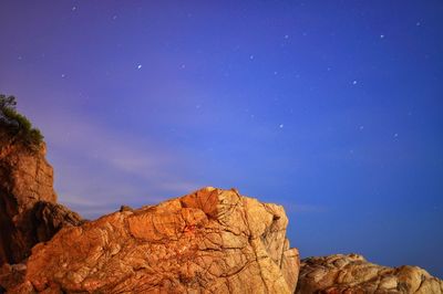 Low angle view of rock formations against blue sky