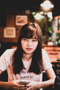 Portrait of young woman sitting in restaurant