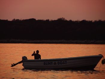 Boat sailing in river at sunset