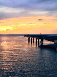 Bridge over river against cloudy sky