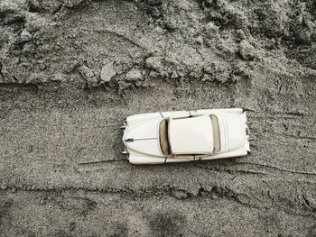 Close-up of sunglasses on sand against wall