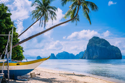 Boat moored at beach against sky