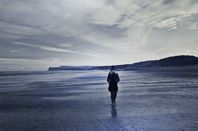 Rear view of man standing on beach