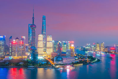 Illuminated buildings in city against sky at night