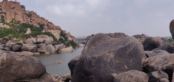 Rocks by sea against sky